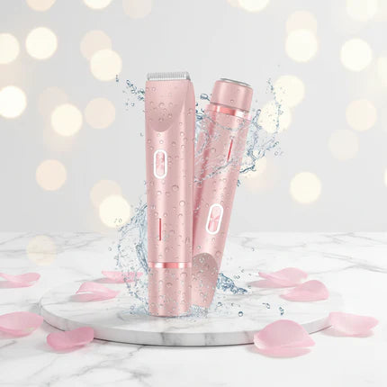 Two pink hair clippers on a marble surface with blurred lights in the background